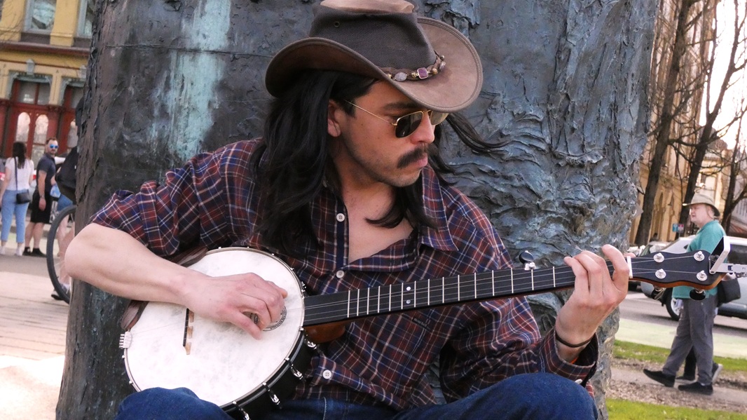 Man in outback hat playing the banjo.