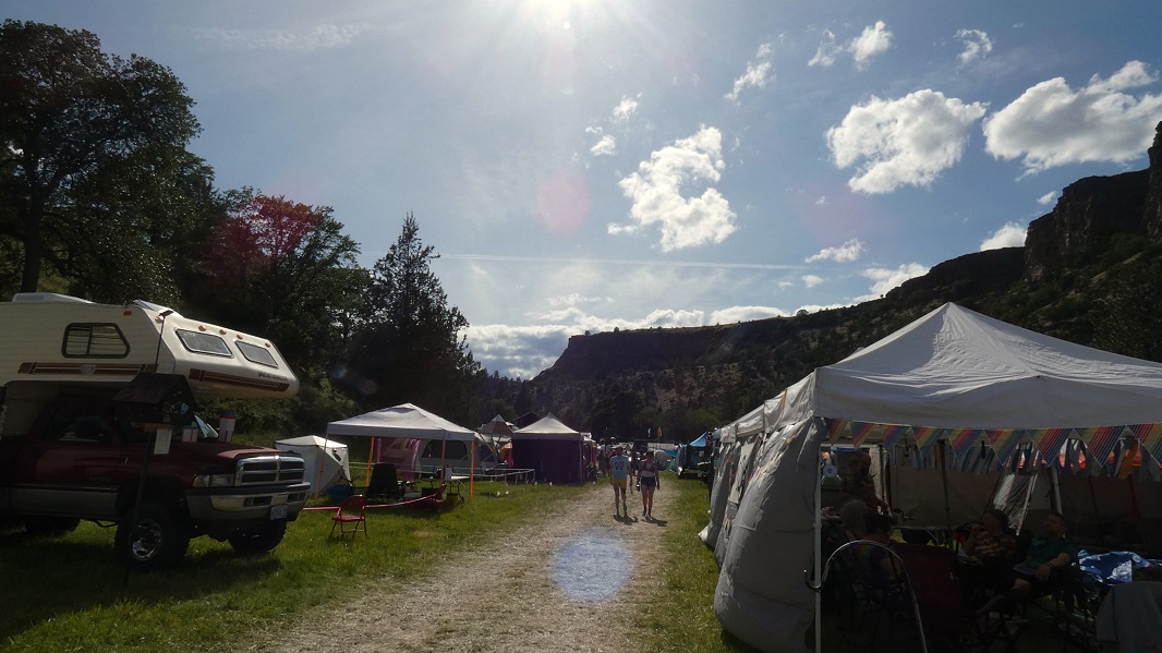 Blue sky with sparse clouds and a hot sun over the main road of the SOAK grounds.