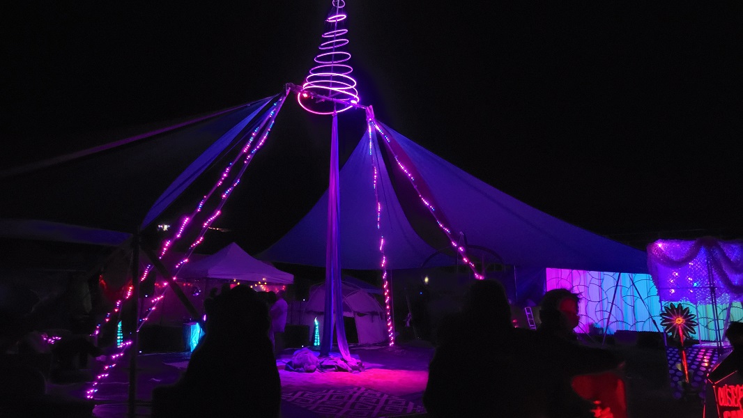 Neon circus tent glows pink all around.