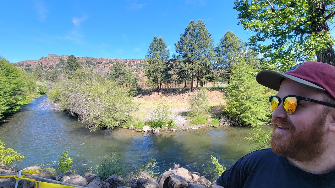 Man in sunglasses smiling in front of White River.